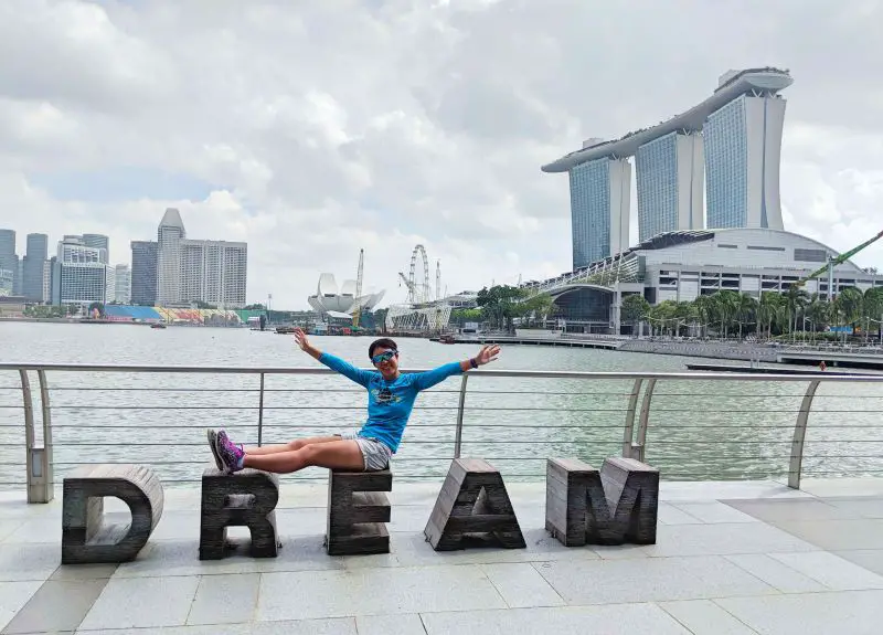 Jackie Szeto, Life Of Doing, sits on a DREAM seating area and overlooking Marina Bay in Singapore.