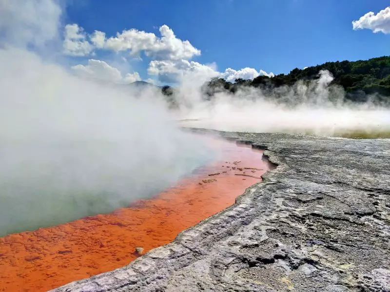 Orange and green geothermal springs with steams coming up at Waiotapu Thermal Wonderland in Rotorua, New Zealand