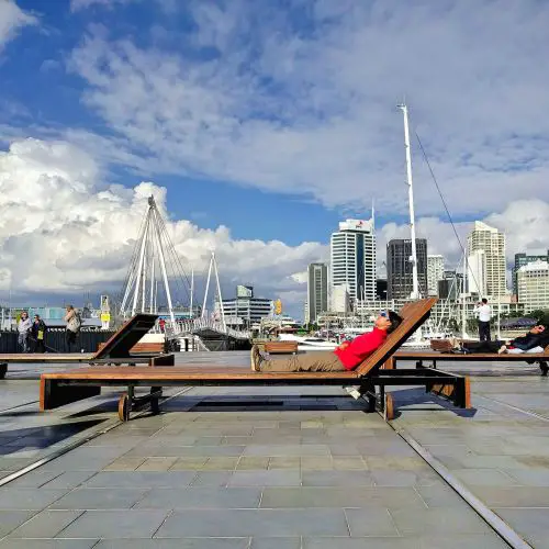 Jackie Szeto, Life Of Doing, lays on the long wooden benches in Wynyard Quarter, Auckland, New Zealand