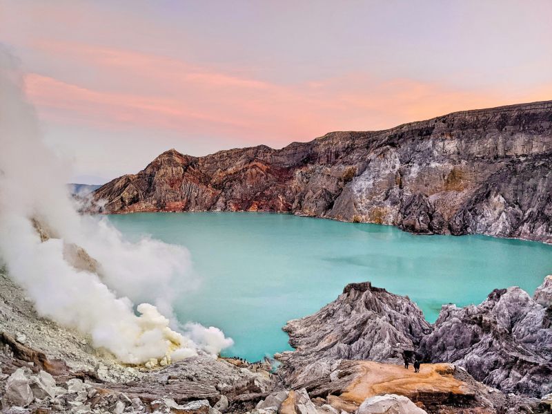 Purple and orange skies as the sun rises at Ijen crater's turquoise lake