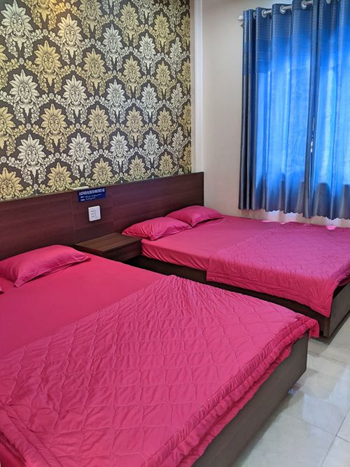 Two double beds with pink bed covers at Huy Hoang Hotel on Nam Du Island