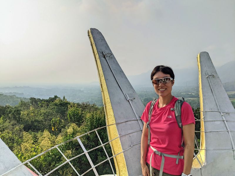 Jackie Szeto, Life Of Doing, stand at the Chicken Church's crown with the forest area view in the background