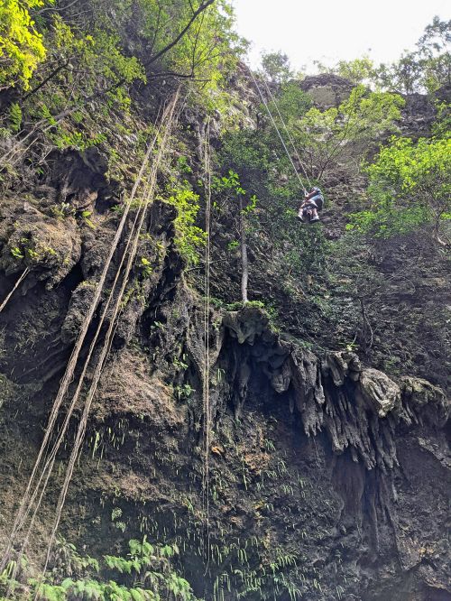 Two people descending down into the Jomblang Cave
