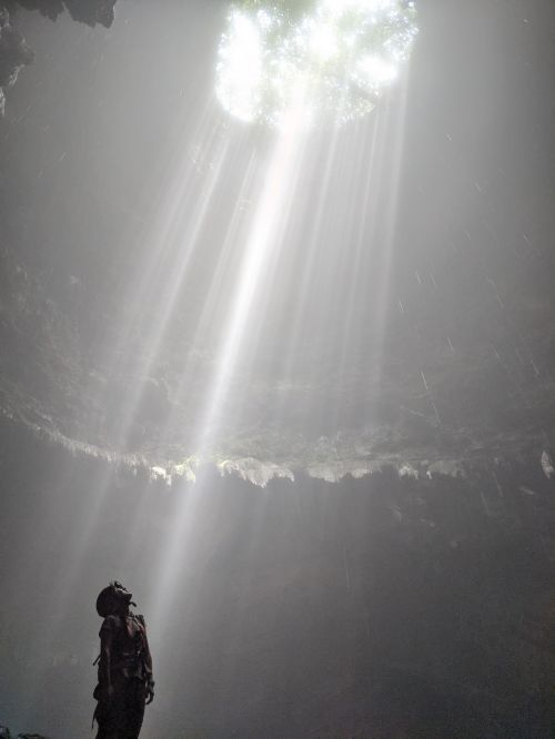 Jackie Szeto, Life Of Doing, looks up into the morning rays inside Jomblang Cave, Indonesia