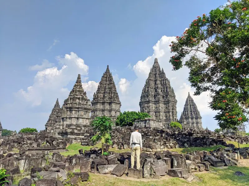 Justin Huynh, Life Of Doing, stands on a rock with a view of the back side of the Prambanan Temple
