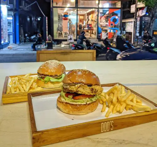 Two wooden trays with two burgers and fries at Dod's Burger in Seminyak, Bali