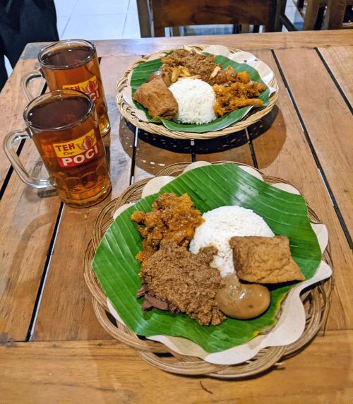 Two plates of rice with tempeh, egg, and gudeg, an Yogyakarta speciality made from unripened jackfruit and coconut cream