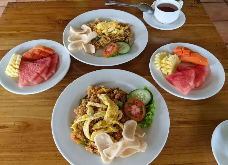 Breakfast at Kubu Cempaka Hotel includes 2 plates of fruit, 1 plate of fried rice, and 1 plate of fried noodles