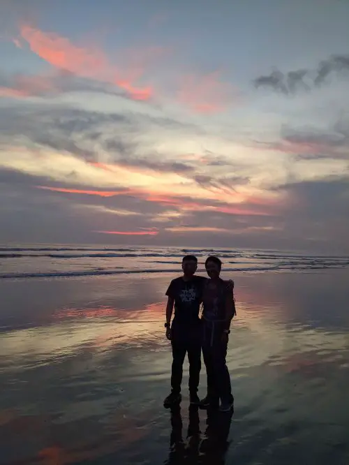 Justin Huynh and Jackie Szeto, Life Of Doing, stand on Seminyak Beach with the sunset