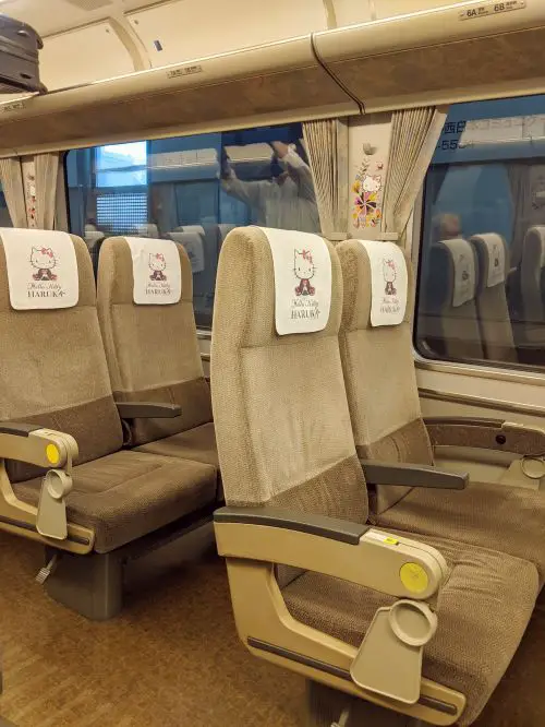Two seats per row with the Hello Kitty themed head cover for the seats inside the Haruka Airport Limited Express train