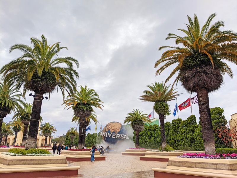 The courtyard area of Universal Studios Japan with seating and palm trees