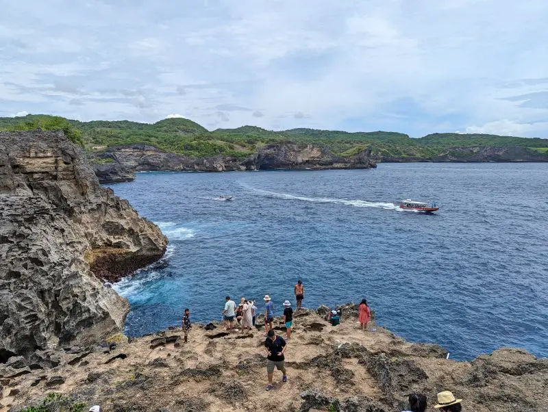 A dozen people taking photos on the edge of the cliffside nearby Angel's Billabong, Nusa Penida