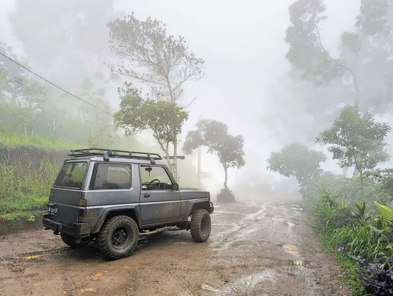 A grey Jeep waiting on the muddy road at Lahangan Sweet, Bali