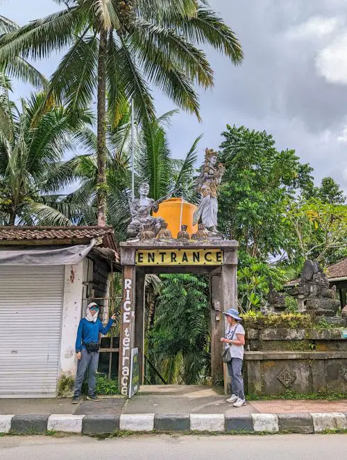 Justin Huynh, Life Of Doing, points to the Rice Terrace Entrance sign to Tegallalang