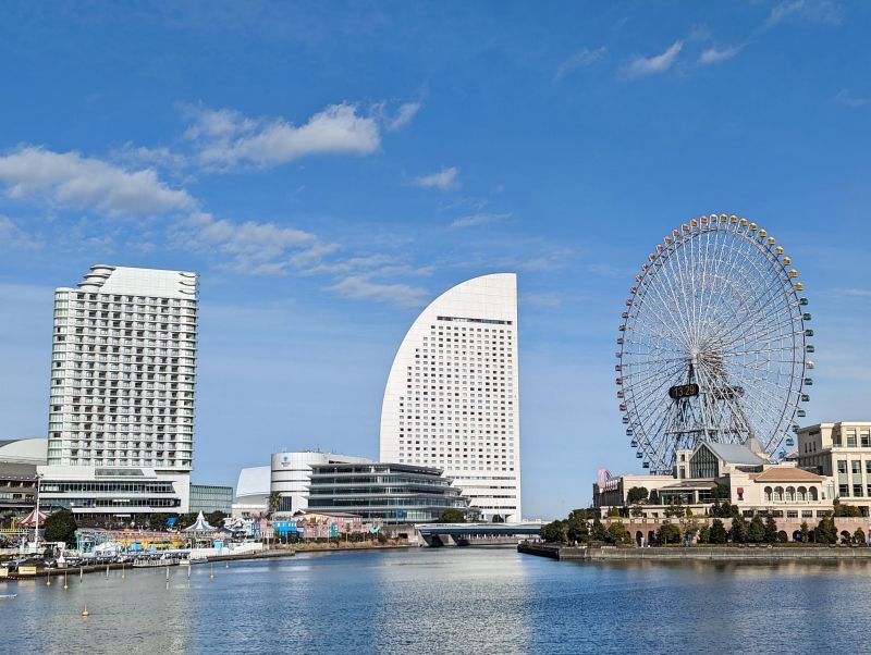 Tall buildings and a Ferris Wheel surrounded by a bay in the Minato Mirai area of Yokohama