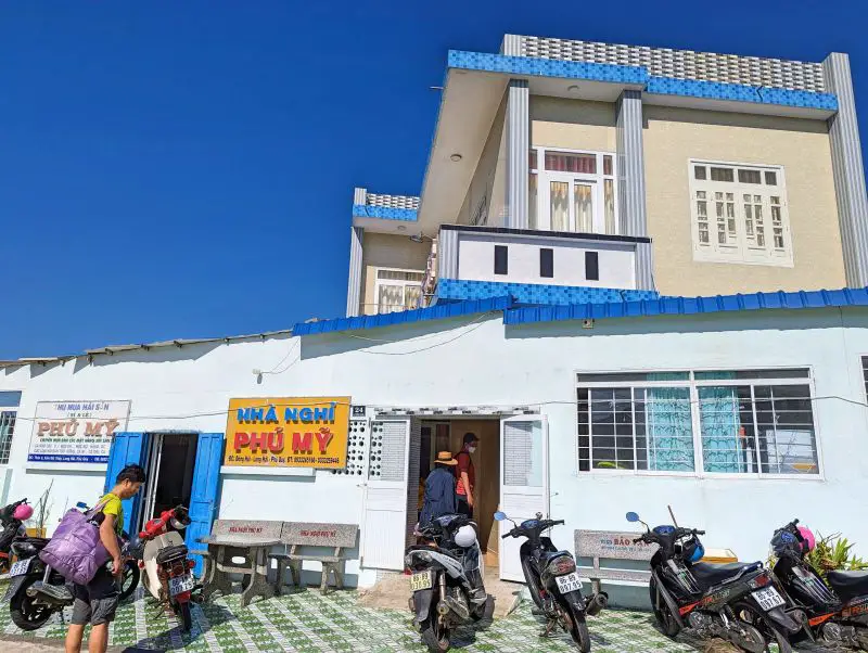 Three people walk into the Nha Nghi Phu My guesthouse on Phu Quy Island