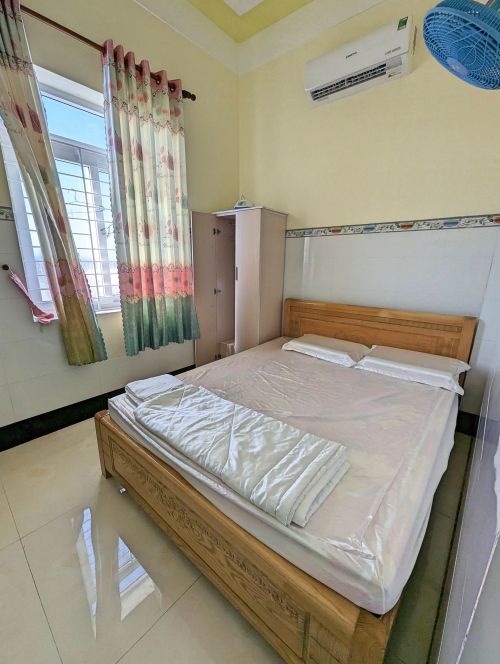 A single room with a bed and clothing cabinet at Nha Nghi Phu My guesthouse, Phu Quy Island