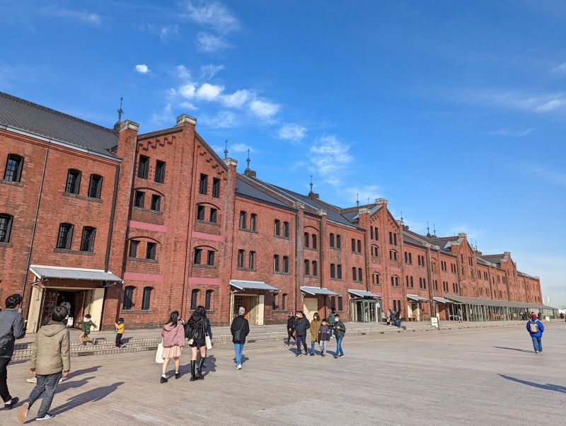 People walking in front of a restored red brick building at the Red Brick Warehouse, Yokohama, Japan
