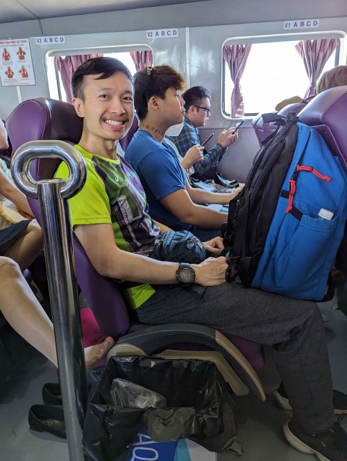 Justin Huynh, Life Of Doing, sits on a purple seat on the Superdong speedboat going to Phu Quy Island