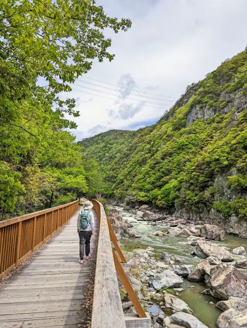 Jackie Szeto, Life Of Doing, walks on the wooden walkway next to the river along Old Fukuchiyama trail