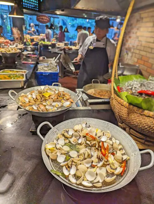 Two large woks with steamed clams at Nha Hang Sen Tay Ho Restaurant in Hanoi