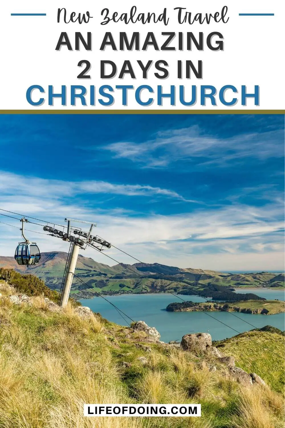 A cable car passing by a blue bay and grassy area in Christchurch, New Zealand