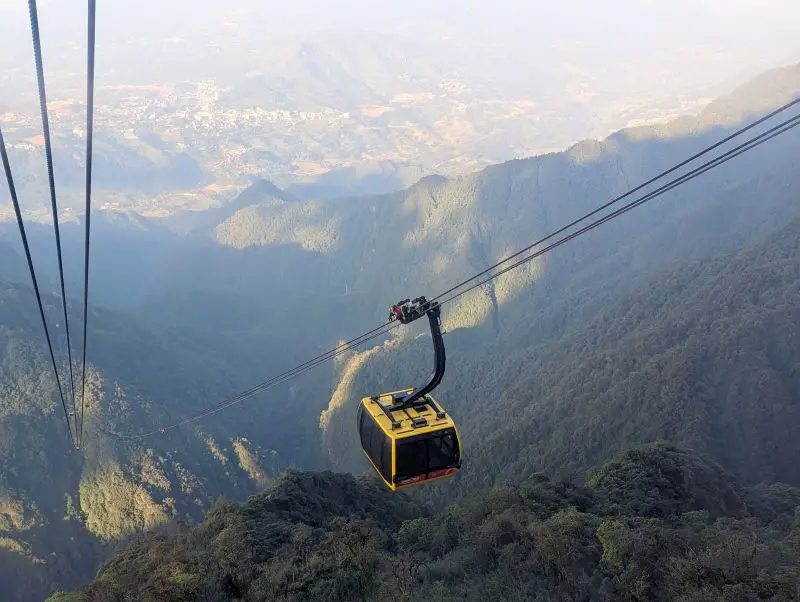 A yellow cable car on the way to Fansipan and passing by the Hoang Lien Mountains
