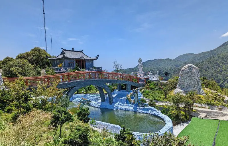 A red bridge, small man-made lake, and small pagoda at the peak of O Quy Ho Heaven Gate in Sapa, Vietnam