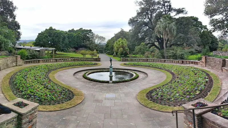 A circular walking path with plants and a small fountain at Royal Botanic Gardens in Sydney, Australia