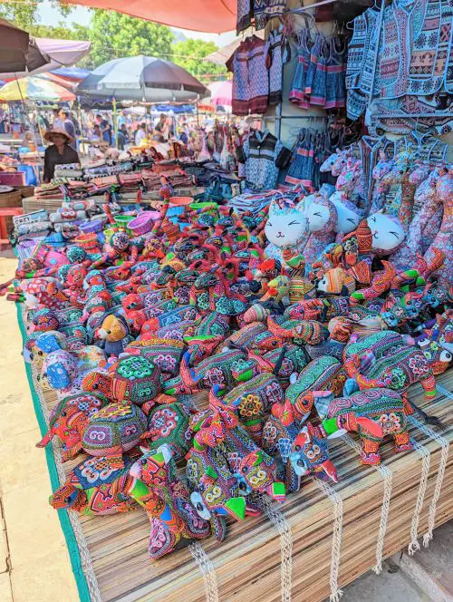 Stuffed animals with unique colorful fabric such as cats, elephants, dogs, and cats for sale at Bac Ha Market
