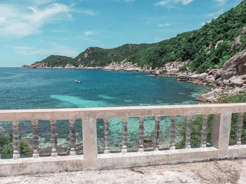 A view of the blue waters and rocky coastline from the balcony area of the abandoned Laem Thian Hotel in Koh Tao, Thailand