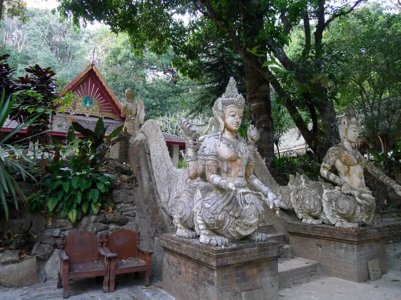 A small temple area with statues at the entrance at Wat Pha Lat in Thailand