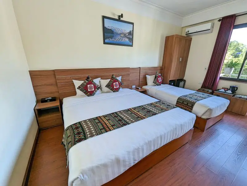 A queen size bed and a twin size bed with ethnic minority patterned pillowcases and bed runner at Sapa Garden Hotel in Sapa, Vietnam