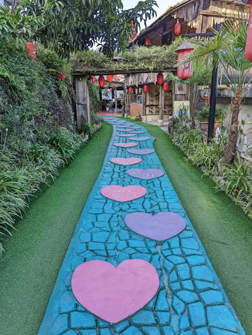 Pink and purple shaped stepping stones on a blue walkway leading to Sapa Garden Hotel entrance in Sapa, Vietnam