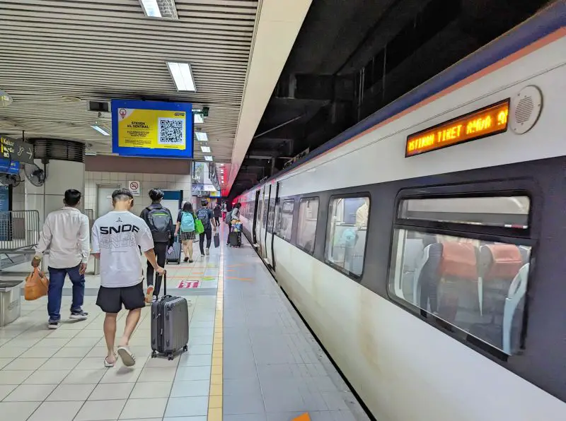 People with luggage walking to their train car at KL Sentral to go to Ipoh