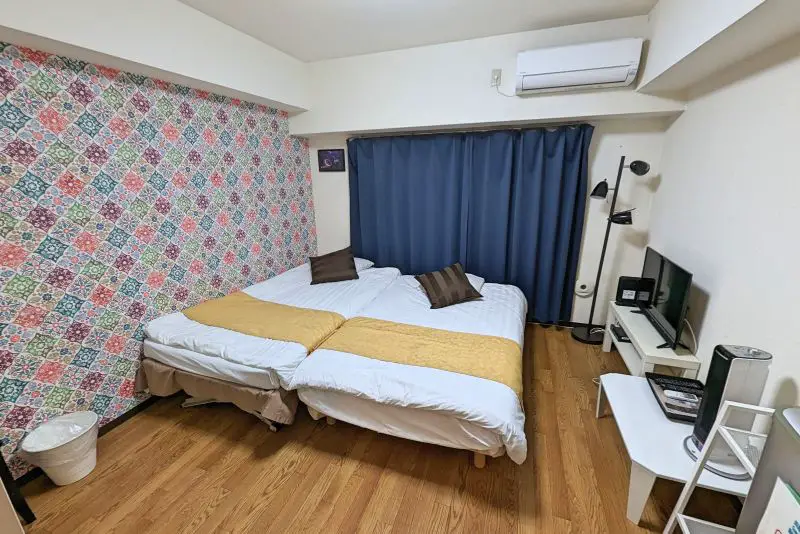 Two twin size beds pushed together in a bedroom at a Japan Airbnb