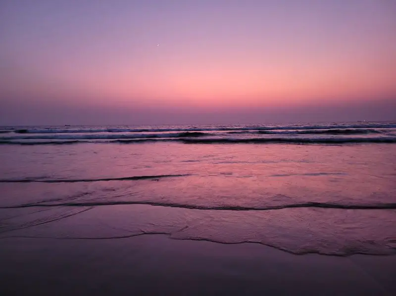 Pink and purple sunsets on a beach in Goa, India