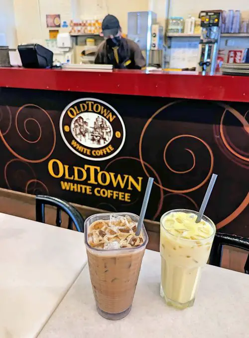An iced coffee and iced pandan oolong tea on a table at Old Town White Coffee in Ipoh, Malaysia