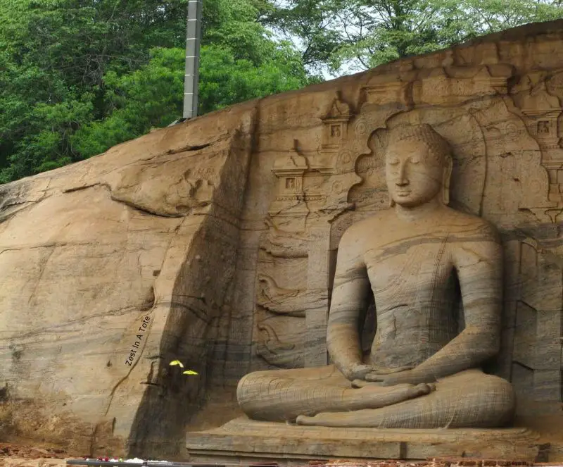 A Buddha statue with its legs crossed carved into a rock at Polonnaruwa, Sri Lanka