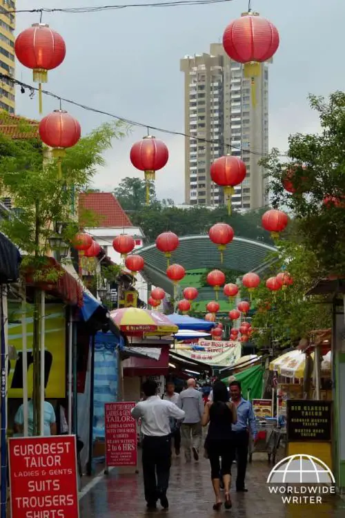 A street in Singapore Chinatown with red lanterns and signs for tailors