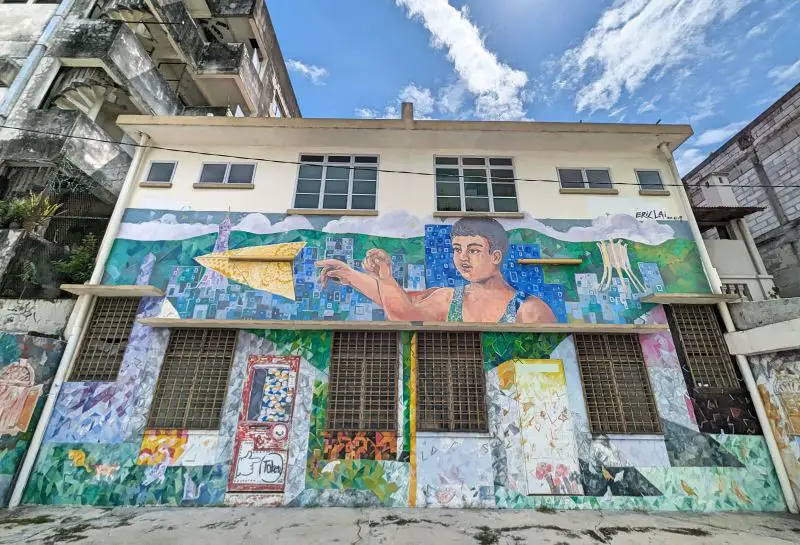 Street art of a boy throwing a paper plane in Ipoh's Mural Art Lane