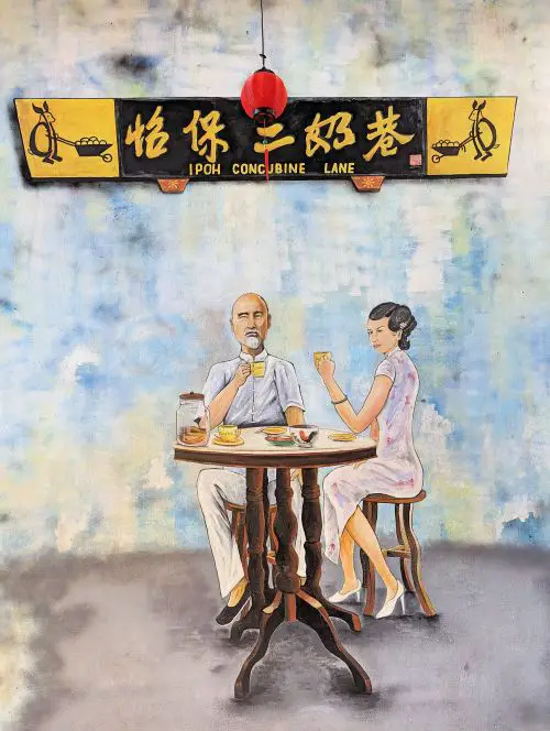 A mural art on Ipoh Concubine Lane of a man and concubine drinking coffee