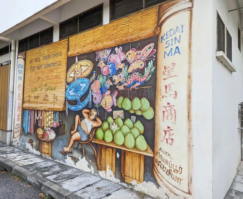 A wall art of a man selling pomelo and decorations in Ipoh