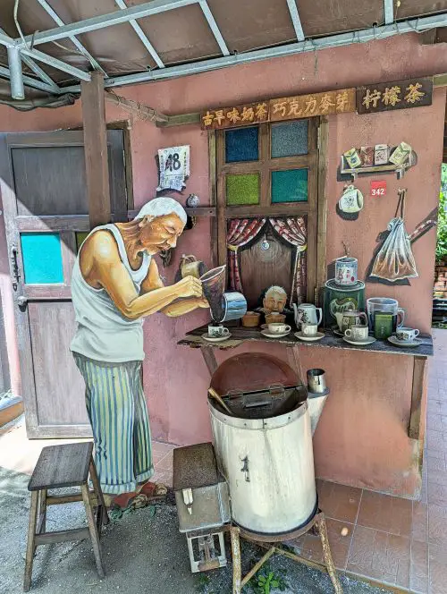 A replica of an old man making coffee at Qing Xin Ling Leisure and Cultural Village