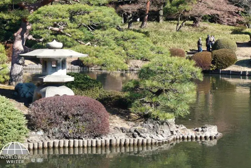 A lantern stone statue on a lake at Shinjuku Gyoen National Garden in Tokyo