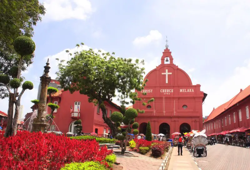 A water fountain to the left of the red Christ Church Melaka in Melaka's Dutch Square, one of the top attractions to visit in Melaka, Malaysia
