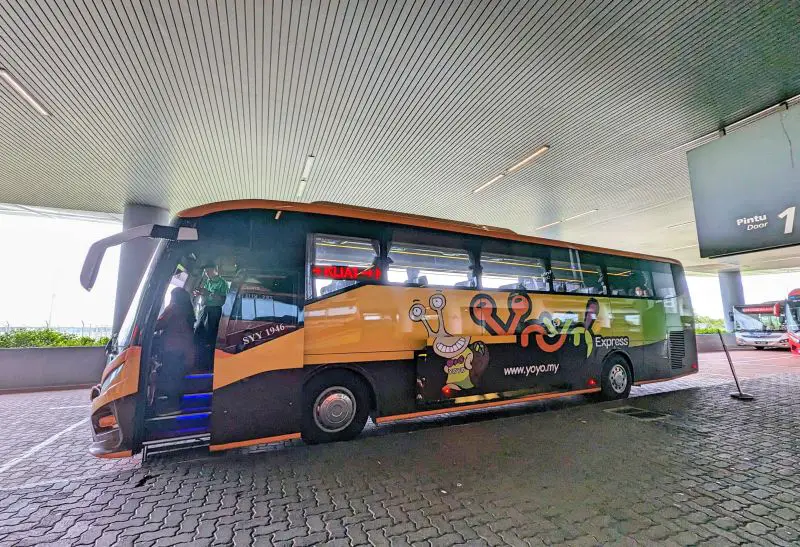 An orange and green Yoyo Express Bus parked at the parking area of KLIA Terminal 2 Bus Area