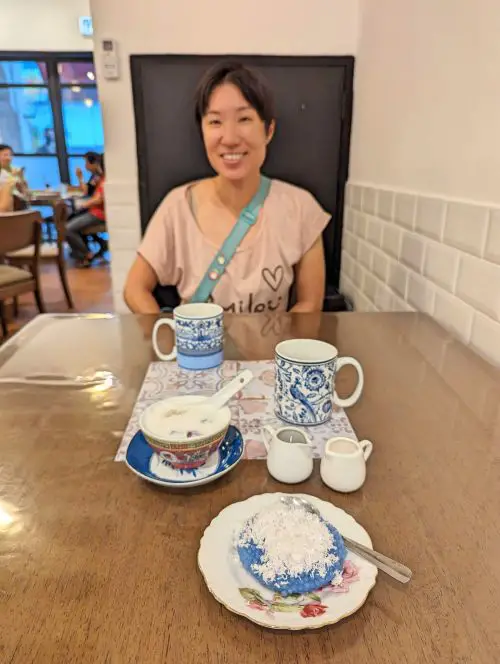 Jackie Szeto, Life Of Doing, smiles as she sees the purple sago dessert with coconut savings and a bowl of sweet potato in coconut milk at Bibik's Kitchen in Penang