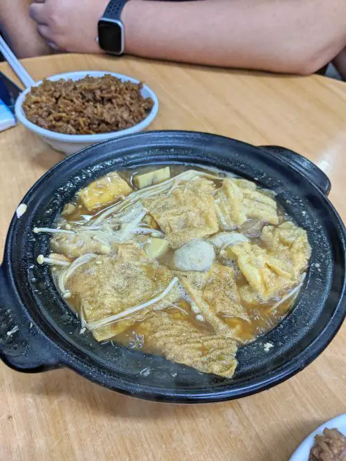 A black sizzling pot of bak kuh teh of pork ribs, enoki mushrooms, and tofu at Khoon Klaang Bak Kuh Teh in Penang