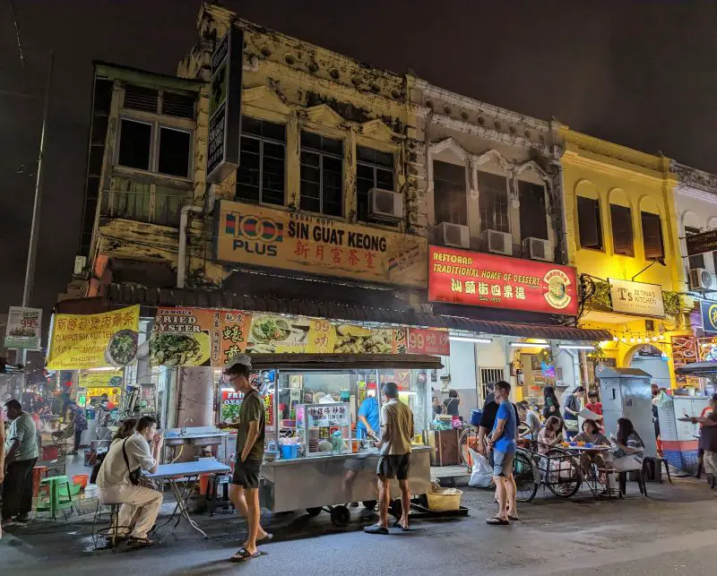 People walking in front of hawker stalls at Kimberley Street Food Night Market in Penang